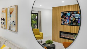A modern living room with a yellow armchair, a fireplace, and a TV wall. - 10 BEDS, 4 BATHS, Sleep 16 in the most Prime Location in Miami!  (Miami)