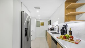A modern kitchen with a stainless steel refrigerator, wooden cabinets, a white countertop, and a variety of fruits and vegetables. - 10 BEDS, 4 BATHS, Sleep 16 in the most Prime Location in Miami!  (Miami)