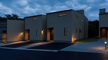 Stylish residential building with a minimalist design, featuring rectangular windows and a covered driveway.