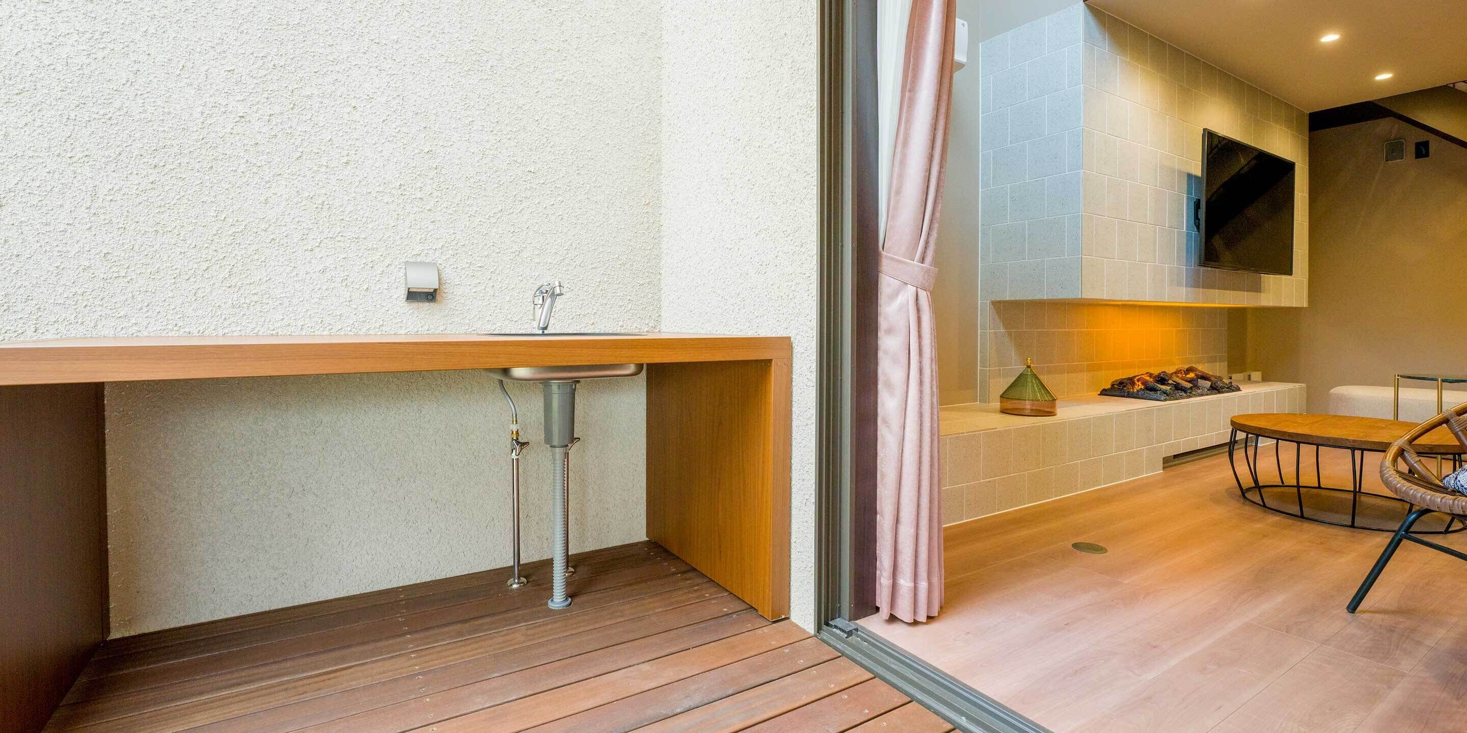 A modern bathroom with a wooden vanity, a sink, and a shower area.