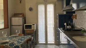 Een keuken met een eethoek, een koelkast, een magnetron en een spoelbak.
