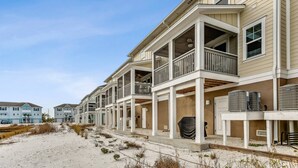 A row of beachfront condominiums with balconies, a sandy beach in the foreground, and a clear sky. - Best Views of the Gulf and Lost Key Beach Club From Your Private Townhome Balcony | 4 Bikes | Pools (Pensacola)