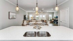 A kitchen with a large island, stainless steel sink, and pendant lighting. - Best Views of the Gulf and Lost Key Beach Club From Your Private Townhome Balcony | 4 Bikes | Pools (Pensacola)