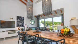 A modern dining area with a wooden table, black chairs, and a fruit bowl. - Villa  with private pool in Moraira, Costa Blanca, Spain for 4 persons (Moraira)