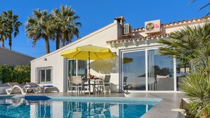 A modern house with a swimming pool, patio furniture, and palm trees. - Villa  with private pool in Moraira, Costa Blanca, Spain for 4 persons (Moraira)