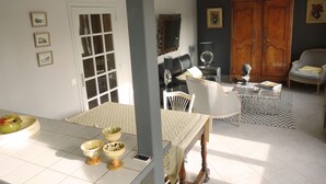 A dining area with a table set for two, a mirror, and a cabinet with a decorative mirror. - Two bedroom apartment in the heart of Vaison la Romaine (Vaison-la-Romaine)