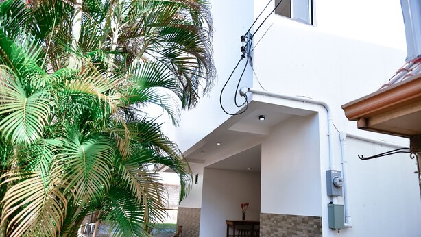 A modern building with a covered outdoor area, a dining table, and a power outlet on the wall.