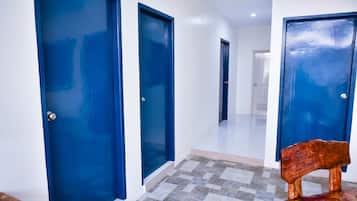 Un pasillo con puertas azules y suelo a cuadros.