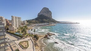 A coastal cityscape with a prominent rock formation, beachfront promenade, and modern buildings. - Apartamento Bernia al Mar by Costa CarpeDiem (Calpe)