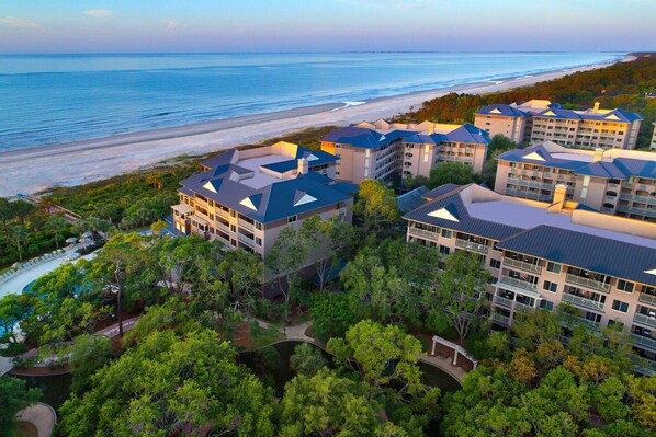 Ein Resort mit mehreren Gebäuden, einem Strand und einem Poolbereich.