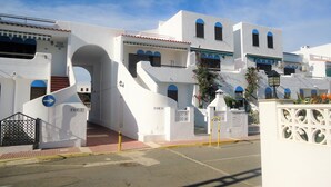 Un edifici blanc amb diversos balcons i portals d'arc.