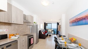Een moderne keuken met een zithoek, een bank en een groot raam met uitzicht op de stad.