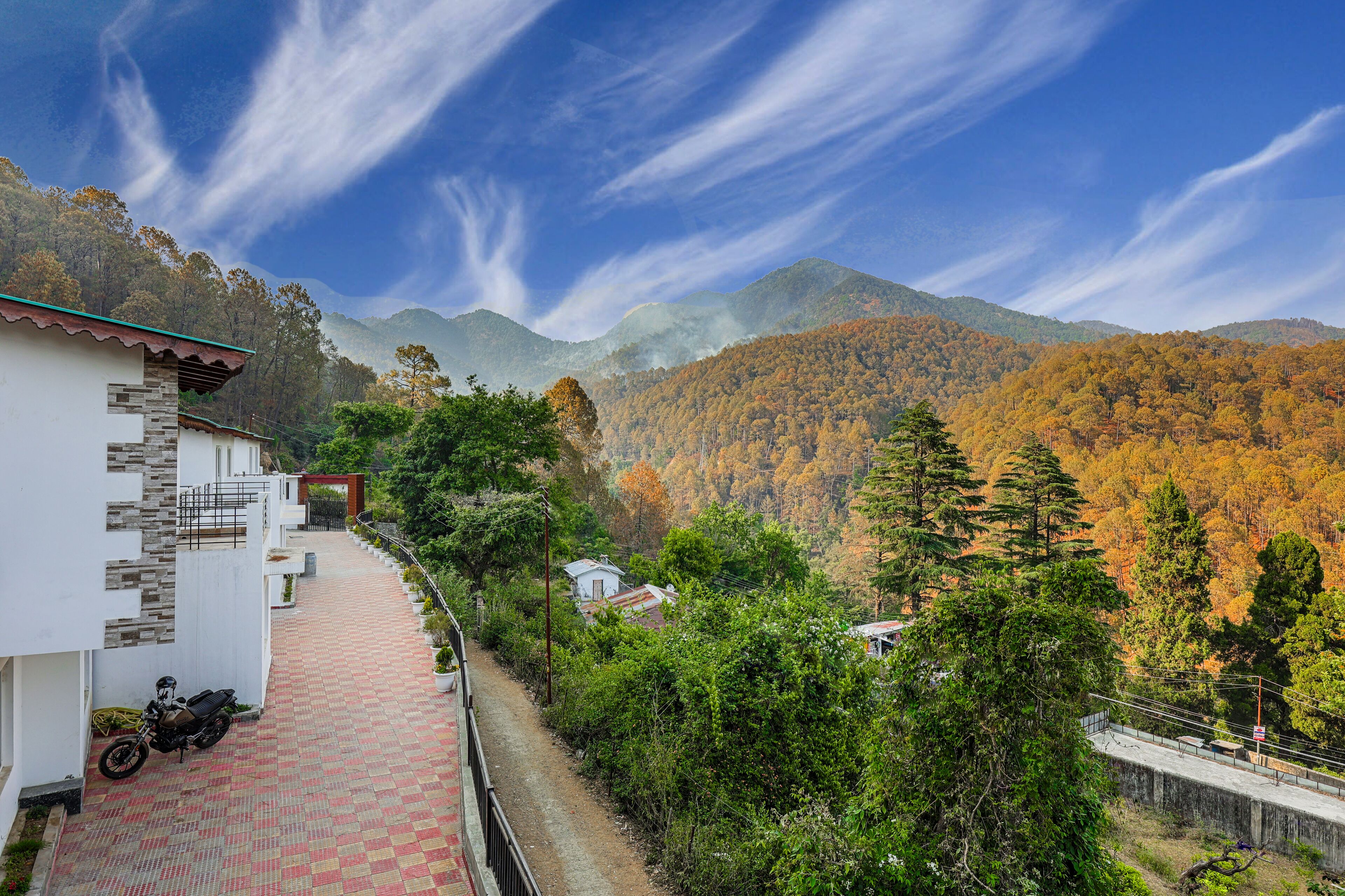 A pathway leading to a building with a mountain backdrop.