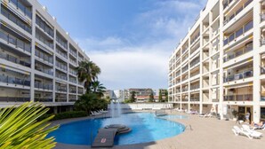 A modern hotel with a central swimming pool, multiple balconies, and a clear sky. - Michelangelo by Interhome (Salou)