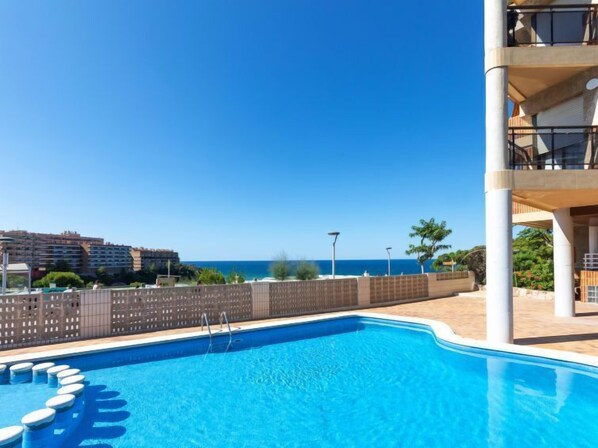 A swimming pool with a clear view of the sea and a building with balconies. - Maresto 1 by Interhome (Salou)