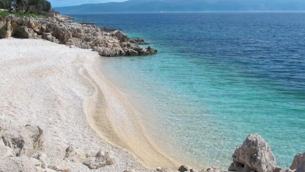 A beach with clear turquoise water and rocky terrain. - Villa Sonia by Interhome (Labin)