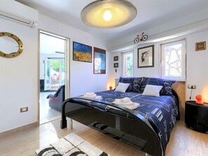 Un dormitorio moderno con una cama, una bicicleta decorativa y vistas al exterior.