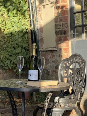 A table with a bottle of wine, two glasses, and a book.