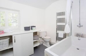 Bathroom features a white toilet, bathtub, and sink area with a countertop.