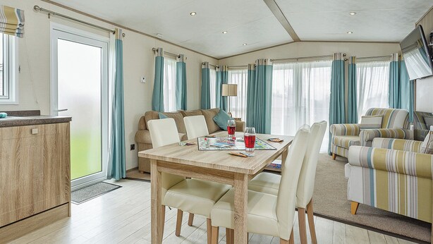 Une pièce spacieuse comprenant une table à manger, des chaises, un canapé et un téléviseur.