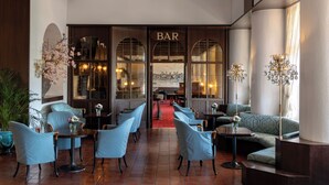 A bar area with seating and a red carpet leading to the bar. - Grand Hotel Europe (Lucerne)