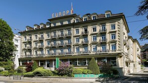 A historic hotel building with multiple balconies and a prominent sign reading "EUROPE". - Grand Hotel Europe (Lucerne)