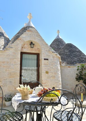 Experience the charm of this traditional stone building, featuring an arched doorway and a cozy balcony area.