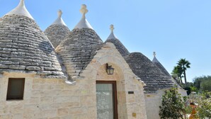 Un edificio con varias construcciones de techo de piedra, una puerta de madera y un ventanal pequeño.