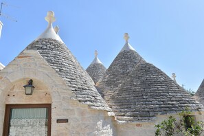 Traditional stone houses with conical roofs, showcasing unique, rounded architecture and local stone materials.