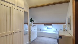 A room with a sloped ceiling, a window with a view, a desk with a lamp, and a wardrobe. - 2 bedroom accommodation in Pontyberem, Carmarthenshire (Pontyberem, Carmarthenshire)
