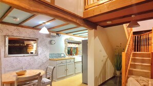 A cozy interior with a dining area, kitchen, and staircase. - 2 bedroom accommodation in Pontyberem, Carmarthenshire (Pontyberem, Carmarthenshire)
