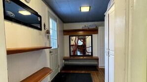 A narrow hallway with wooden flooring, white walls, and a window with red curtains. - Cozy, Warm & Spacious Fernie Bungalow (Fernie)
