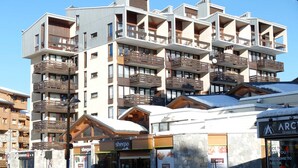 A multi-story hotel with balconies, a ski resort sign, and a Sherpa store. - Renovated bright studio with balcony - Close to slopes (Tignes)