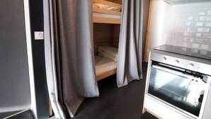 A compact kitchen with a modern stove and a small dining area. - Renovated bright studio with balcony - Close to slopes (Tignes)