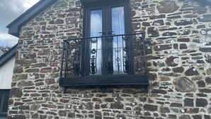 A stone building with a window and a balcony.