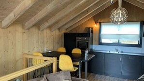 Un interior acogedor de madera con comedor, cocina y sofá.
