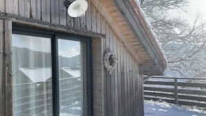 Una cabaña de madera con un ventanal grande y una chimenea.