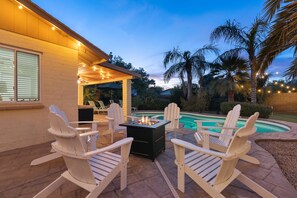 An outdoor patio with Adirondack chairs, a fire pit, and a pool. - Scottsdale Tropical Paradise - Heated Pool! Hot Tub! Golf! Amazing Yard! (Scottsdale)