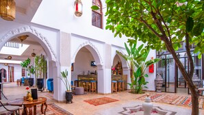 Un intérieur spacieux agrémenté d’arches, d’un bar et d’un espace détente avec des tables et des chaises.