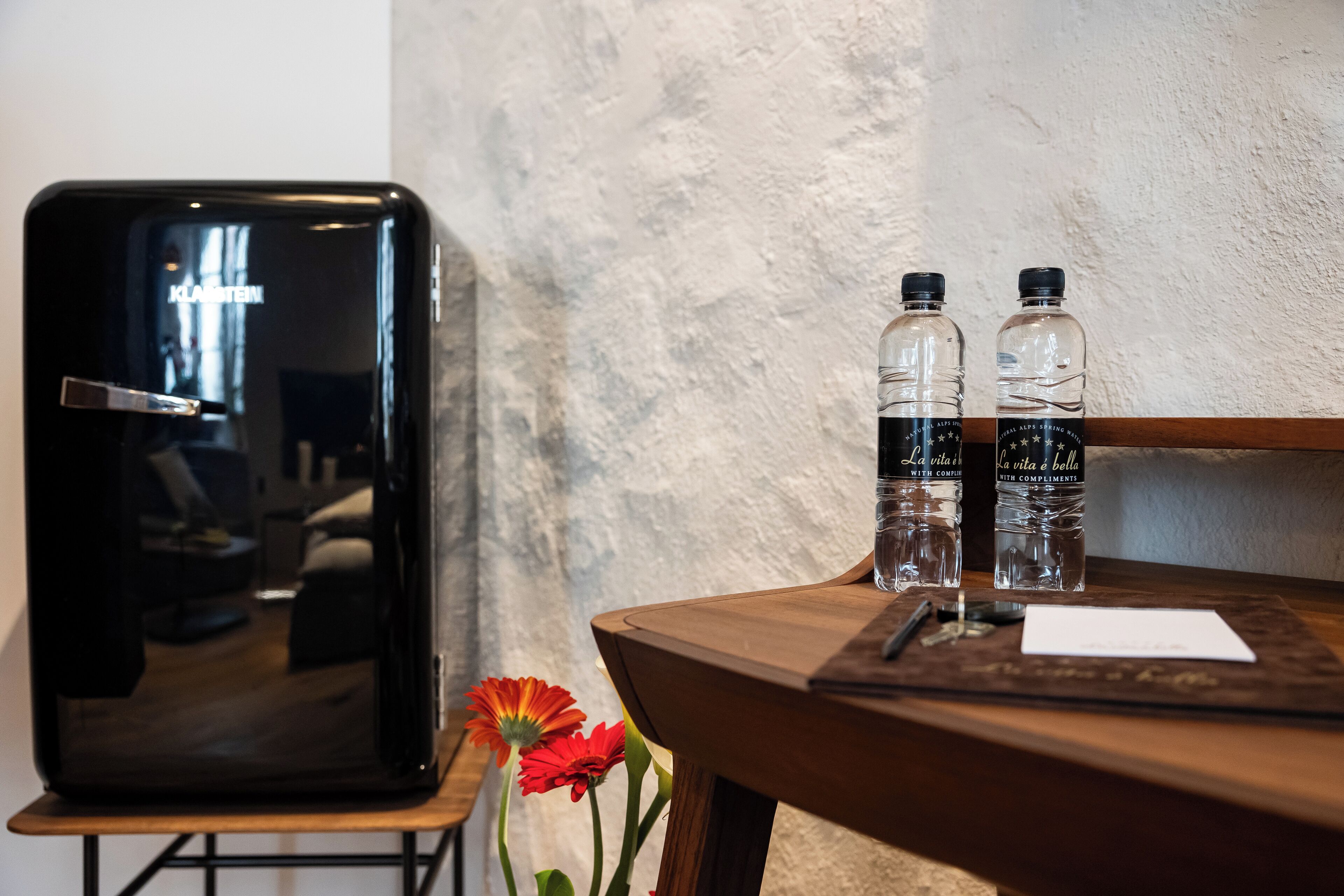 Una mesa de madera con dos botellas de agua y un teléfono inteligente.