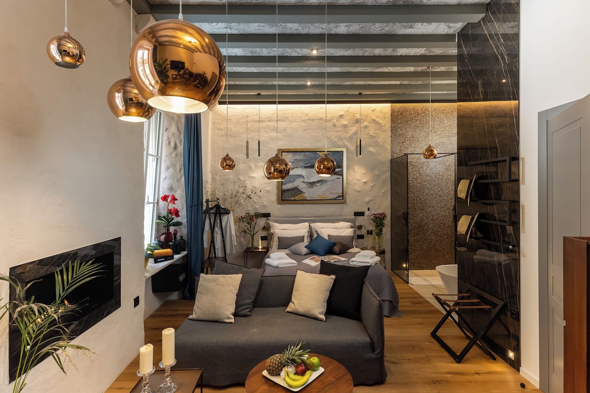 Un salon moderne avec un canapé, une cheminée et un coin repas avec une table mise pour deux personnes.