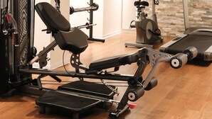 A home gym with exercise equipment, a treadmill, and a TV. - VISIONAPARTMENTS Zurich Brandschenkestrasse (Zürich)