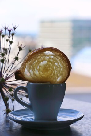 A cup with a pastry on top, placed on a saucer. - VISIONAPARTMENTS Zurich Brandschenkestrasse (Zürich)