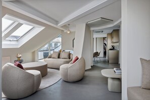 Ein modernes Wohnzimmer mit hohen Decken, Oberlichtern und Blick auf die Stadtlandschaft.