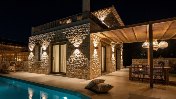 A stone building with a pool, outdoor seating, and a pergola with hanging lights. - PAPADRIA VILLAS as featured in THE TIMES - Modern Luxury Getaway nr Kathisma (Tsoukalades)