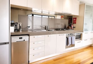 Une cuisine moderne équipée d’un lave-vaisselle, d’un four et d’un four à micro-ondes intégrés.