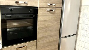 Une cuisine équipée d’un four encastré et d’un réfrigérateur en acier inoxydable.