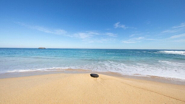 A beach with clear blue water and a single rock in the sand. - HOUSE ON THE BEACH, FOZ (Unknown)