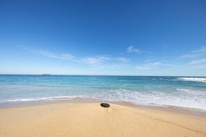 A beach with clear blue water and a single rock in the sand. - BEACH HOUSE, FOZ (Unknown)