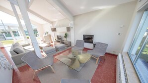 A modern living room with a glass coffee table, grey upholstered chairs, a sofa, and a TV. - HOUSE ON THE BEACH, FOZ (Unknown)